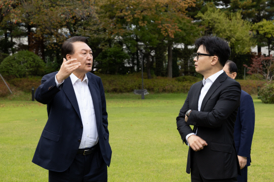 지난 10월21일 윤석열 대통령이 서울 용산 대통령실 파인그라스 앞 잔디마당에서 한동훈 국민의힘 대표를 만나 대화하고 있다.<대통령실 제공·연합뉴스>